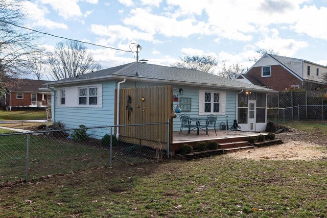 rear view of house with a yard, a sunroom, and a deck