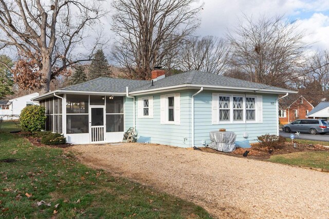 back of property featuring a yard and a sunroom