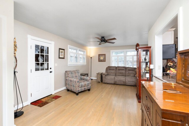 living room with ceiling fan and light hardwood / wood-style flooring