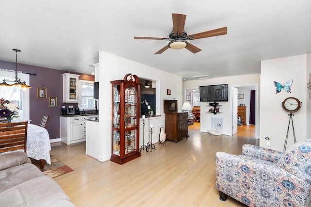 living room featuring ceiling fan and light wood-type flooring