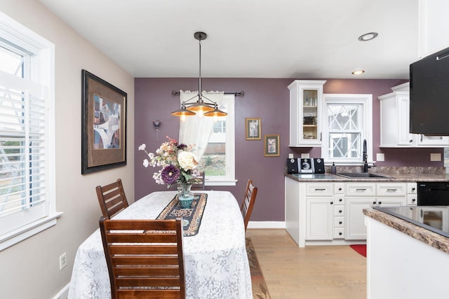 dining space with light hardwood / wood-style floors and sink