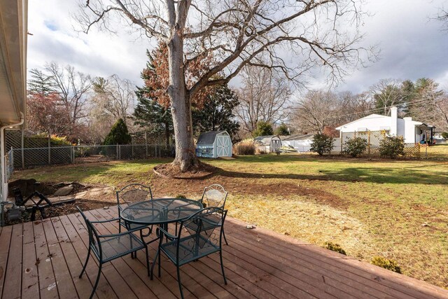 wooden deck with a shed and a yard