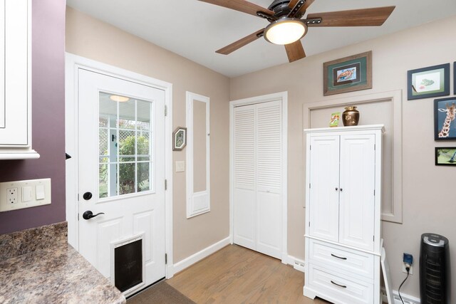 doorway with ceiling fan and light hardwood / wood-style floors