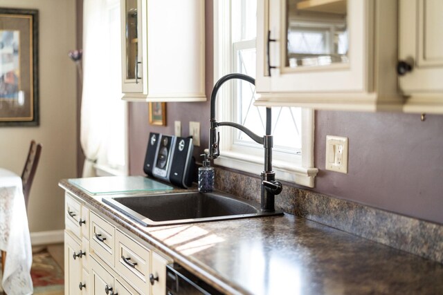 kitchen featuring sink, cream cabinetry, and black dishwasher