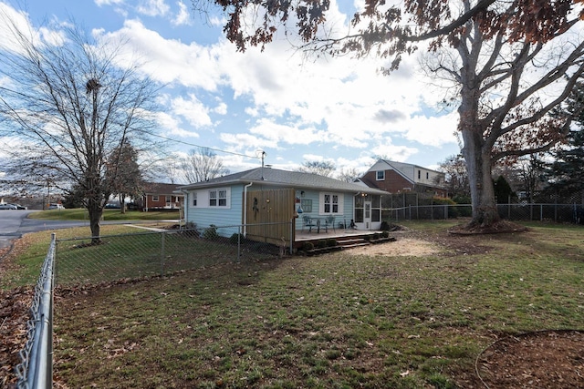 back of house with a wooden deck and a lawn