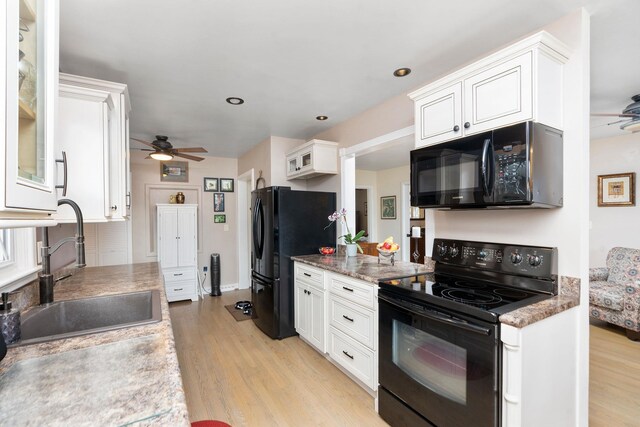 kitchen with sink, ceiling fan, white cabinetry, black appliances, and light hardwood / wood-style floors