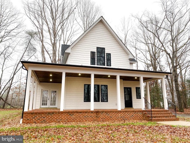 view of front of property featuring french doors, a porch, and brick siding