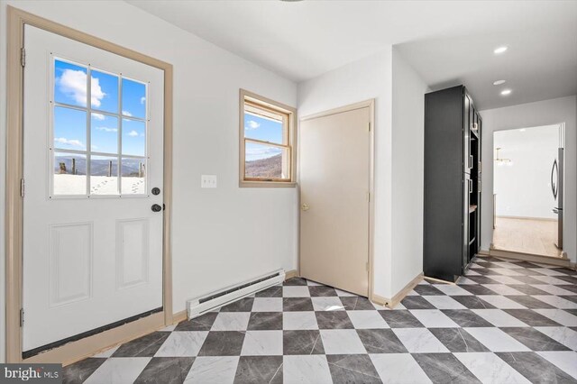 foyer entrance with a baseboard heating unit