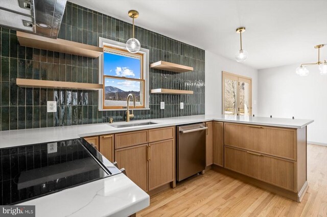 kitchen featuring sink, hanging light fixtures, light hardwood / wood-style floors, decorative backsplash, and kitchen peninsula