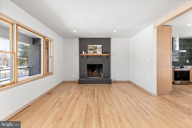 unfurnished living room with a fireplace and light wood-type flooring