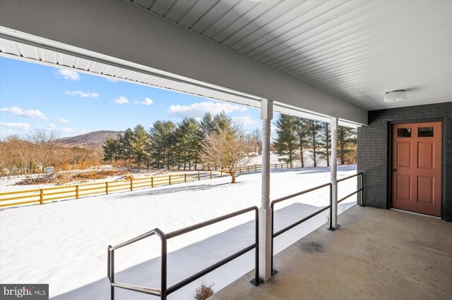 snow covered patio featuring a mountain view