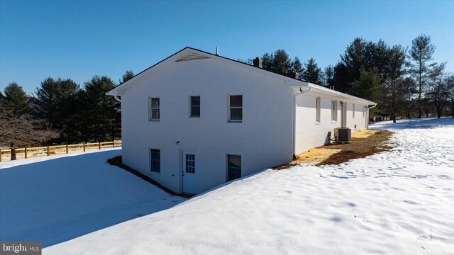 snow covered property featuring central air condition unit