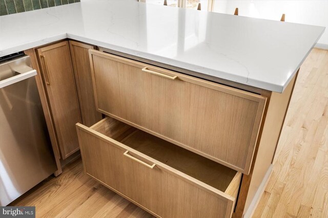 details with dishwasher, light stone countertops, and light hardwood / wood-style flooring