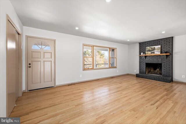 unfurnished living room with a fireplace and light hardwood / wood-style flooring