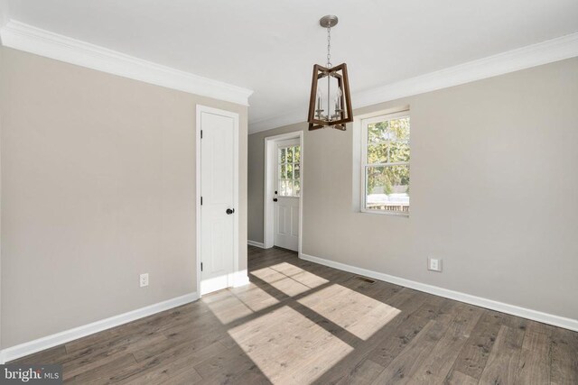 unfurnished dining area with an inviting chandelier, crown molding, and dark hardwood / wood-style floors