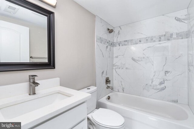 full bathroom with vanity, toilet, and tiled shower / bath