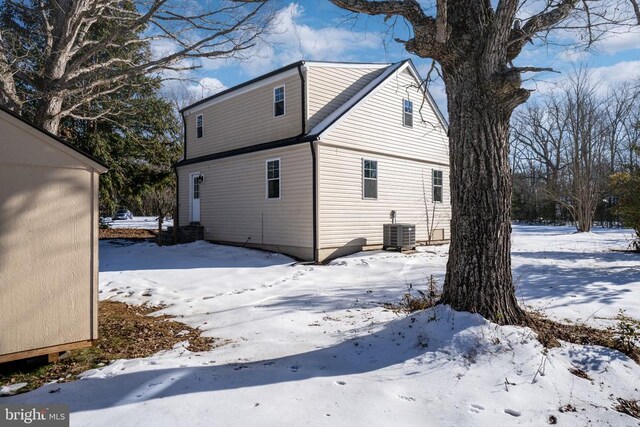 snow covered house with central air condition unit