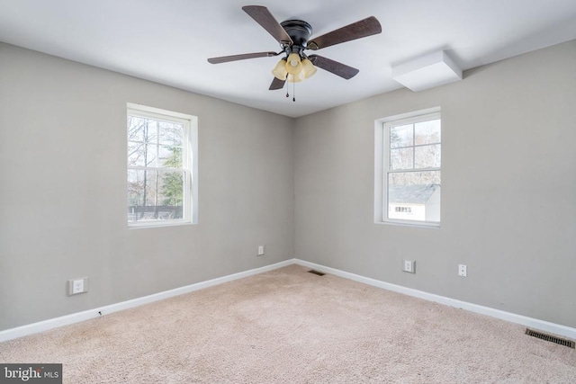 carpeted spare room featuring ceiling fan