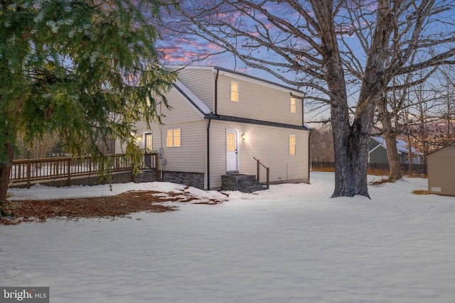 view of snow covered back of property