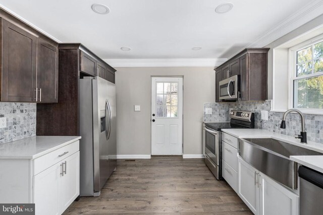 kitchen with white cabinetry, appliances with stainless steel finishes, sink, and a healthy amount of sunlight