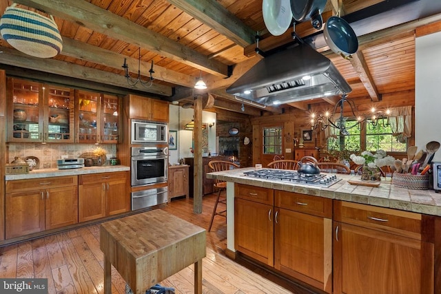 kitchen with stainless steel appliances, island range hood, wood ceiling, and a warming drawer