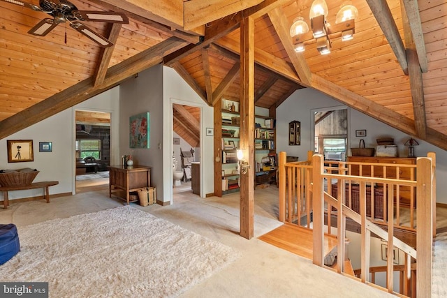 additional living space with lofted ceiling with beams, wood ceiling, a wealth of natural light, and carpet
