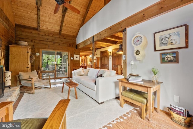living room with wood walls, beam ceiling, ceiling fan, high vaulted ceiling, and wooden ceiling