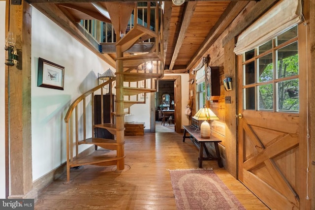 stairway with beamed ceiling, wood ceiling, and wood-type flooring