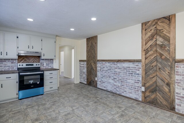 kitchen featuring white cabinetry, stainless steel electric stove, and a textured ceiling