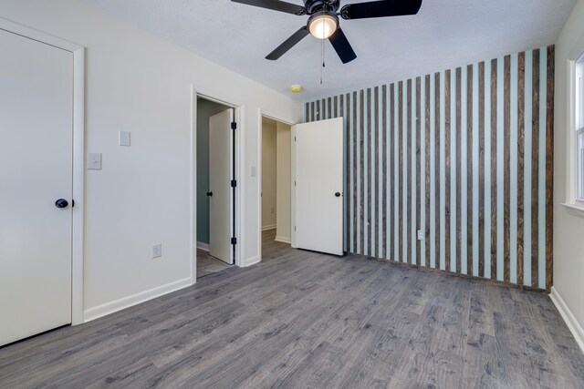 unfurnished bedroom with ceiling fan, wood-type flooring, and a textured ceiling