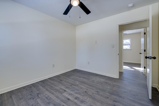 unfurnished room with dark wood-type flooring and ceiling fan