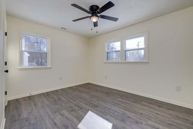 unfurnished room featuring dark wood-type flooring, a wealth of natural light, and ceiling fan