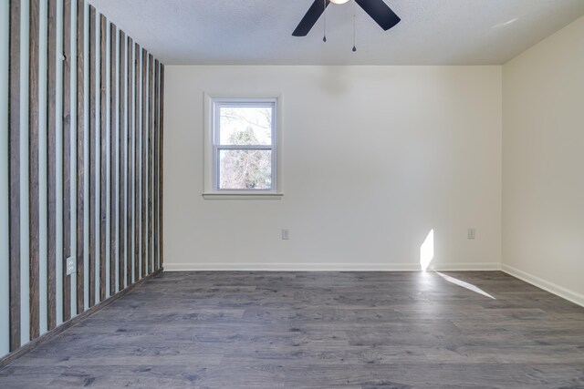 spare room with ceiling fan, dark wood-type flooring, and a textured ceiling