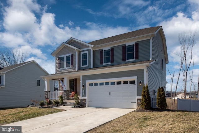 craftsman-style home featuring fence, concrete driveway, covered porch, stone siding, and an attached garage