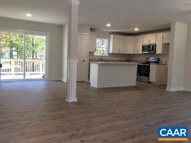 kitchen with white cabinetry, dark hardwood / wood-style flooring, and light stone counters