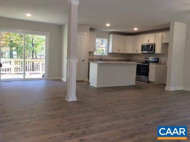 kitchen with dark hardwood / wood-style floors, white cabinetry, sink, backsplash, and stainless steel appliances