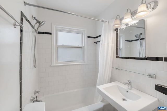 bathroom featuring shower / tub combo with curtain, sink, and tile walls