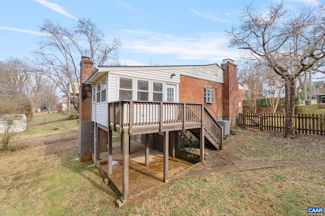 back of property featuring a wooden deck, a yard, and central AC unit