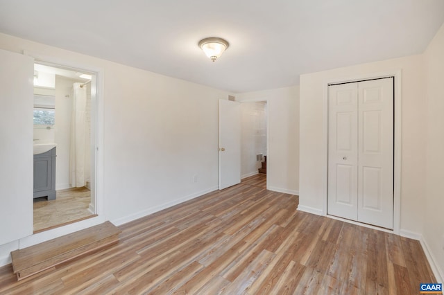 unfurnished bedroom with light hardwood / wood-style flooring and a closet