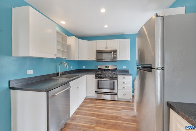 kitchen featuring white cabinetry, sink, stainless steel appliances, and light hardwood / wood-style floors