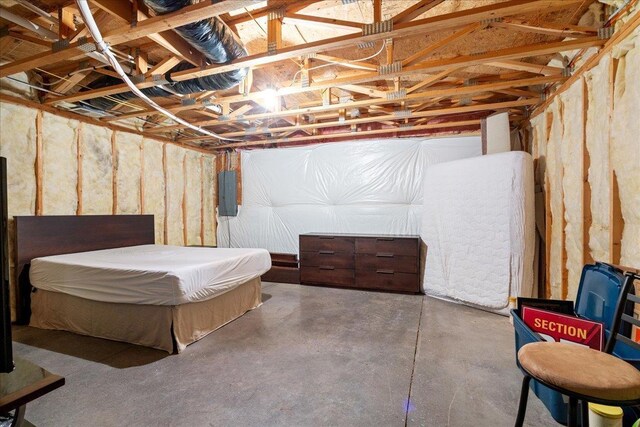 bedroom featuring electric panel and concrete floors