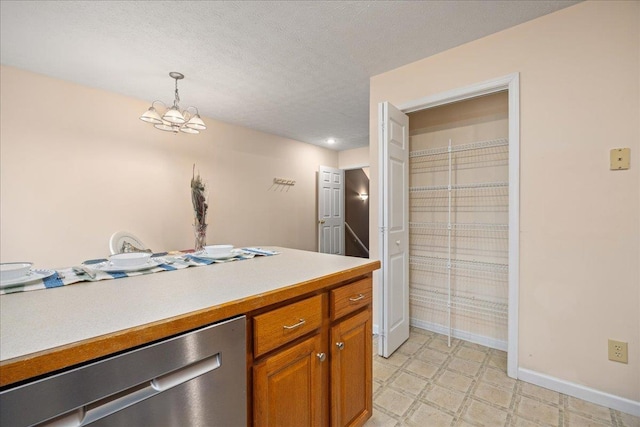 kitchen featuring pendant lighting, a textured ceiling, and a notable chandelier