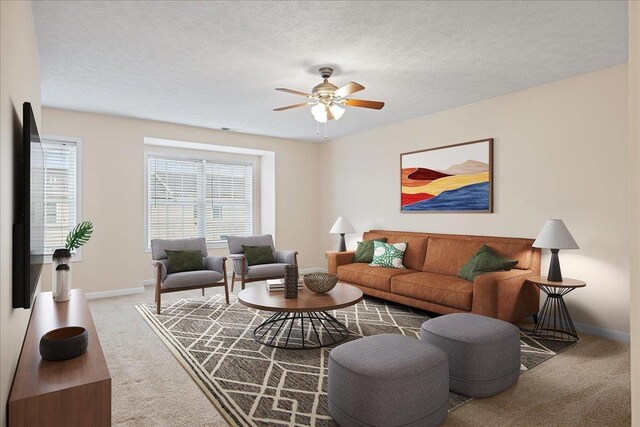 carpeted living room with ceiling fan, a wealth of natural light, and a textured ceiling