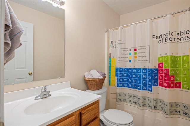 bathroom with vanity, toilet, curtained shower, and a textured ceiling