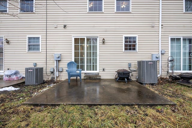 back of property with a patio, central AC unit, and a fire pit