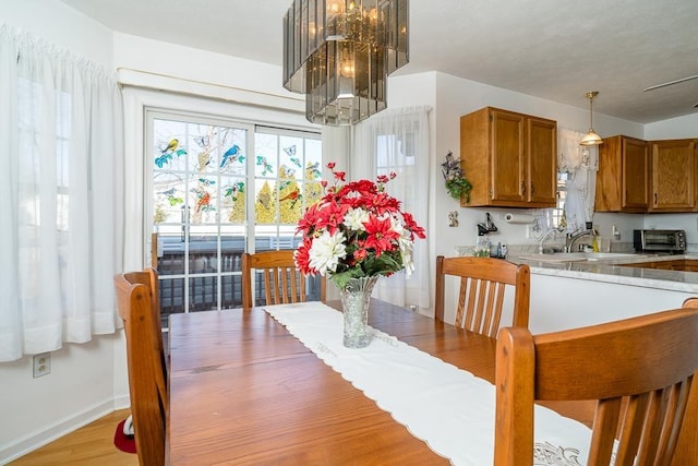 dining area featuring an inviting chandelier, a toaster, and baseboards