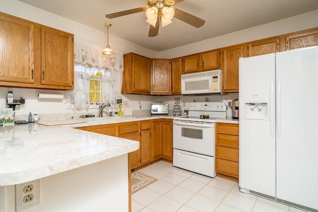 kitchen featuring light countertops, white appliances, brown cabinetry, and a peninsula