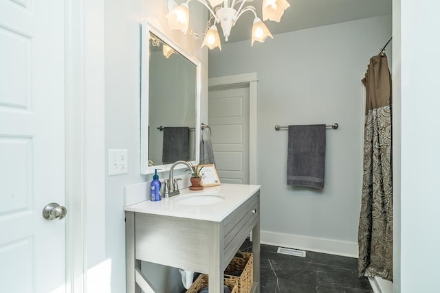 bathroom featuring an inviting chandelier, vanity, and walk in shower