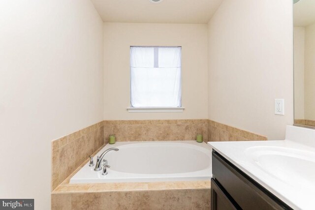 bathroom featuring vanity and tiled bath