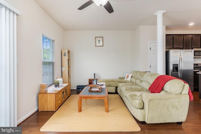 living room with decorative columns, dark hardwood / wood-style floors, and ceiling fan